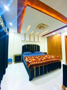 拉合尔Luxury Apartment in Bahria Town, Lahore的一间位于客房内的蓝色床卧室