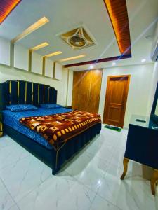 拉合尔Luxury Apartment in Bahria Town, Lahore的一间卧室配有一张带蓝色棉被的床