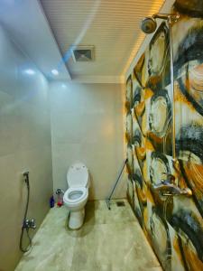 拉合尔Luxury Apartment in Bahria Town, Lahore的一间带卫生间的浴室和墙上的绘画