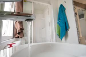 杜纳维德Adria Holiday Villaggio San Francesco的浴室设有水槽,墙上有一条蓝色毛巾。
