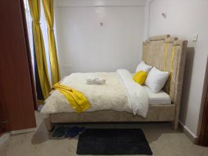 KerichoSerene 2 Bedrooms Apartment的床上有黄色枕头,有黄色的毯子