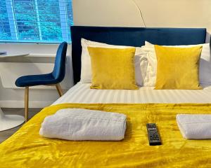 伯恩茅斯Serenity Retreat - Tranquil Apartment Close to Beach的一张带两条毛巾的床和遥控器
