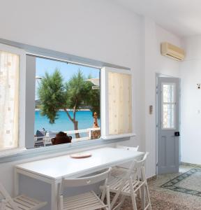 普拉提伊亚洛斯西弗诺斯Grandma's sifnos house的白色的用餐室设有可欣赏海滩美景的窗户。