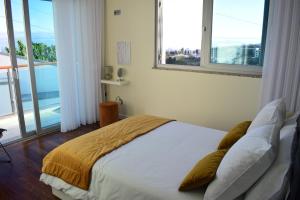 丰沙尔Moradia Vista Atlântico的一间卧室设有一张大床和两个窗户