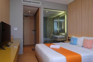 DemanganSans Hotel RG Living Jogja by RedDoorz的一间卧室配有一张大床和电视