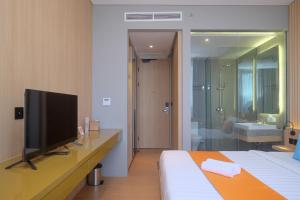 DemanganSans Hotel RG Living Jogja by RedDoorz的酒店的客房 - 带一张床、一台电视和一间浴室