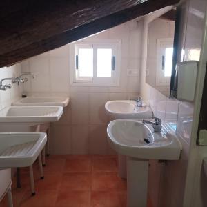 CiratEl Albergue Cirat的一间带三个盥洗盆和窗户的浴室