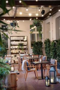 布拉格Falkensteiner Boutique Hotel Prague的一间设有桌椅的餐厅,种植了植物