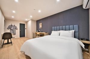浦项Hotel Daon的一间卧室配有一张白色大床和蓝色的墙壁