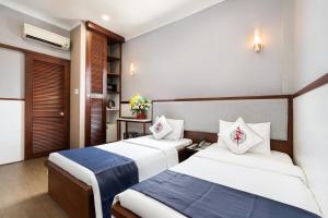 胡志明市Văn Hoa Hotel的配有两张床的酒店客房中的两张床