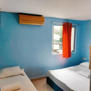 吉隆坡RAS Hotel的蓝色墙壁客房的两张床