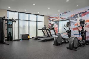 卡尔曼Home2 Suites By Hilton Cullman的健身房设有心肺功能训练器材和大窗户