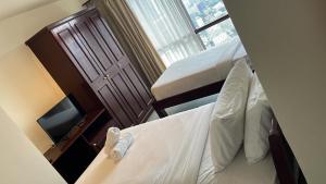 吉隆坡RESORT SUITES AT BARJAYA TIMES SQUARE kL的小房间设有两张床和窗户
