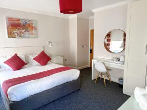 布莱顿霍夫传奇酒店的配有一张床和一张书桌的酒店客房