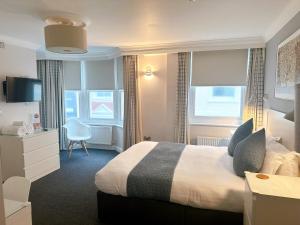布莱顿霍夫传奇酒店的酒店客房设有一张床、一张书桌和窗户。