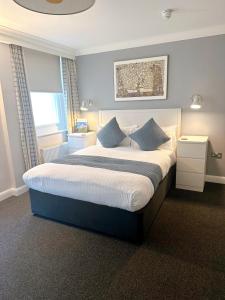 布莱顿霍夫传奇酒店的一间卧室配有一张带蓝色枕头的大床
