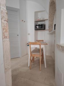 普蒂尼亚诺Archi Antichi的厨房配有微波炉,配有桌椅