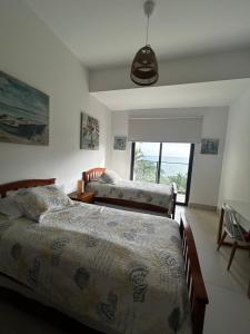 圣卡洛斯Charming Zen-style Beach apartment at Punta Caelo的一间卧室设有两张床和窗户。