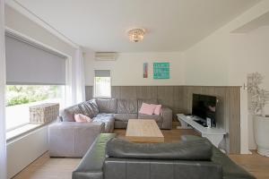 登海尔德Villa Pakhuys - groepsaccommodatie - Julianadorp aan Zee的客厅配有沙发和桌子