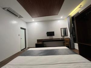 木州县Happy House Moc Chau的一间卧室配有一张床、一张书桌和一台电视