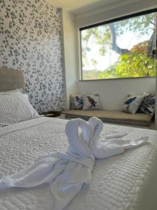 马塔迪圣若昂Village Ninho da Jandaia的铺在床上的白色毯子,床上有窗