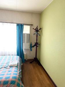 富良野PENSION YunShuiYao雲水瑶民宿的客房设有带一张床和风扇的卧室。