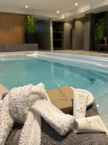 韦克舍埃斯普拉达酒店的游泳池旁的毛巾和杯子