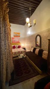 拉巴特DAR LALLA Aicha 2的一间卧室配有一张床、一张沙发和一面镜子