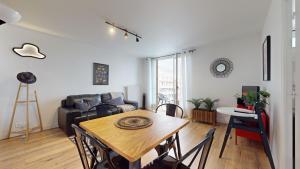 维勒班Appartement PLEIN-CIEL的客厅配有桌子和沙发