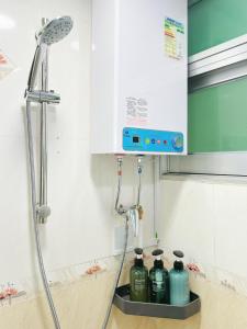 香港Student Accommodation - 26 Man Yuen Street的带淋浴的浴室,在柜台上配有4瓶