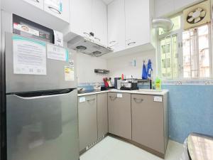 香港Student Accommodation - 26 Man Yuen Street的厨房配有不锈钢冰箱和橱柜