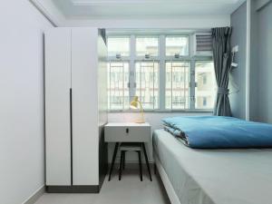 香港Student Accommodation - 26 Man Yuen Street的一间卧室配有一张床、一张书桌和一个窗户。