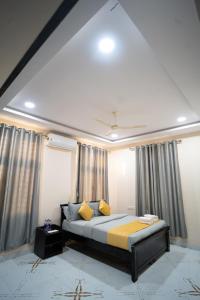 海得拉巴Yellow Bells Gachibowli的一间卧室配有一张带黄色枕头和窗帘的床