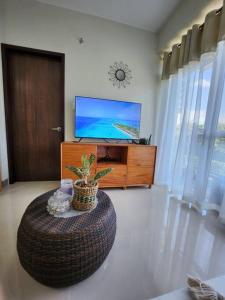 长滩岛Aloha Ocean Garden Villas Boracay的客厅配有大搁脚凳和电视