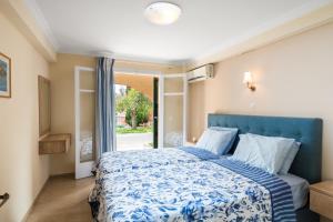 古维亚Marietta's Resort by Konnect, Gouvia Corfu的一间卧室设有蓝色的床和窗户。
