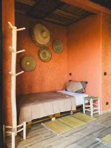 阿加迪尔Panorama Guesthouse的一间卧室配有一张床,墙上挂着一些帽子