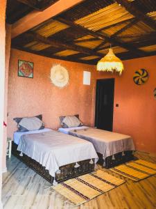 阿加迪尔Panorama Guesthouse的橙色墙壁客房的两张床