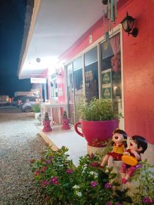 班武里府桑拉克度假村的两个娃娃坐在粉红色建筑外面