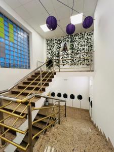 萨格勒布Appa Hostel的紫色吊灯间的楼梯