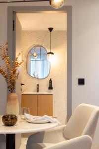 波尔图Icon Apartments by NÔMA的厨房配有桌子、椅子和镜子
