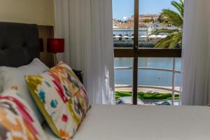 塔维拉Princesa do Gilão的一张带窗户的床铺,享有海港的景色