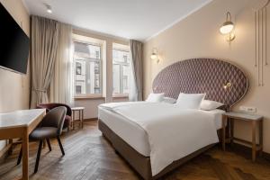 卢布尔雅那Grand Hotel Union Eurostars的酒店客房设有一张大床和一张书桌。