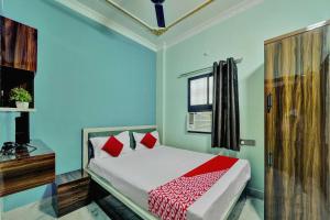 巴特那OYO Flagship Hotel R P Royal的一间卧室配有一张蓝色墙壁的床和一扇窗户