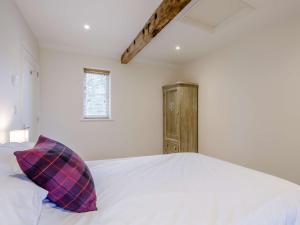 Wootton Glanville1 bed in Sherborne 80737的卧室配有白色床和紫色枕头