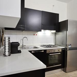 奥尔贾泰奥洛纳Casa Moderna Olgiate的厨房配有不锈钢用具和黑色橱柜