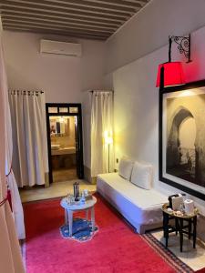 马拉喀什RIAD ENNAFOURA BOUTIQUE HOTEL的卧室配有白色的床和桌子