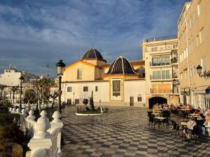 贝尼多姆Benidorm Old Town House with lounge area的一群坐在大楼前桌旁的人