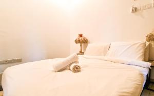 峇六拜The Best Hotel in Bayan Lepas - THE LOV PENANG的一张白色的床,上面有一条毛巾
