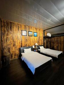 木州县Thênh Thang Home & Cafe的木墙客房的两张床
