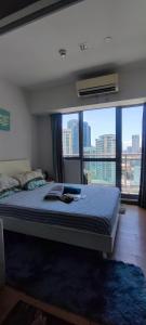 马尼拉Aveline Suites Cozy Skyline View ACQUA Private Residences near Rockwell Makati的一间卧室设有一张大床和大窗户